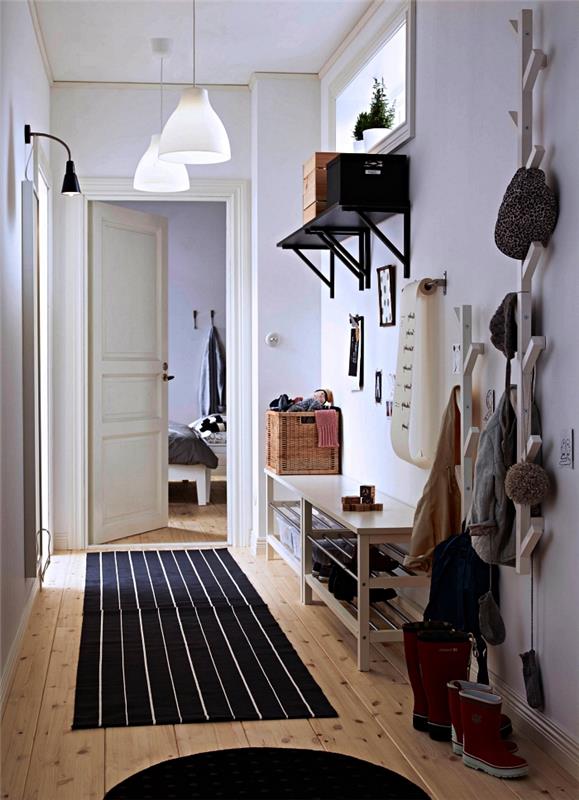 vhodna klop s shrambo za čevlje in belo pobarvano leseno stensko omaro, majhen vhod v skandinavskem slogu z lesenim parketom in belo pobarvanimi stenami