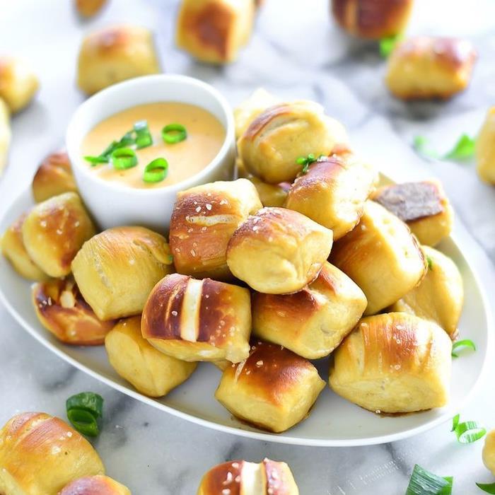 Aperitivo vegano con dei piccoli panini al formaggio e contorno di salsa con erba cipollina