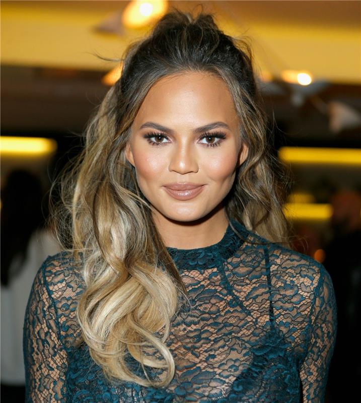 chrissy teigen in njena pričeska za okrogel obraz, pol čop s prostimi prameni, ki uokvirjajo obraz, lahki kodri