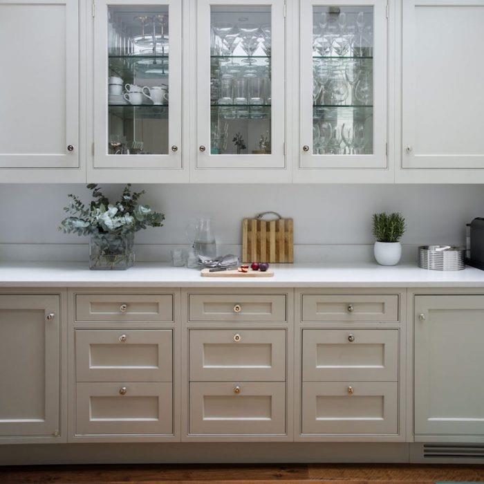 miško siva slika sprednje kuhinje in bele visoke omare, bela delovna plošča, okrasne zelene rastline