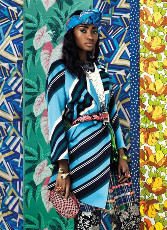 moteris su spalvinga audinio diadema ant ilgų garbanotų plaukų, afrikietiško ilgo sijono, afrikietiško nugarinės stiliaus, juostelėmis ir gėlių raštais