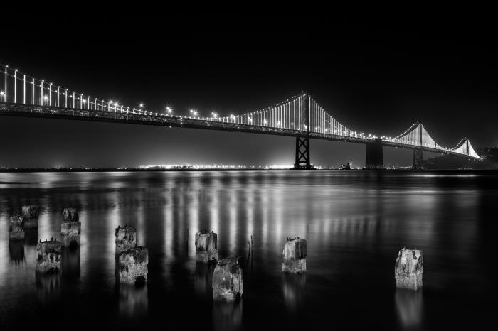 panoramski pogled na most san francisco in njegovih tisoč luči, ki se odražajo v zrcalu vode, urbana pokrajina za tiskanje v črno -belem plakatu