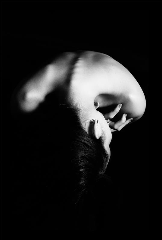 Črno -bela fotografija hrbta ženske, enobarvno slikanje, vesela, da vidi njene kul ozadje