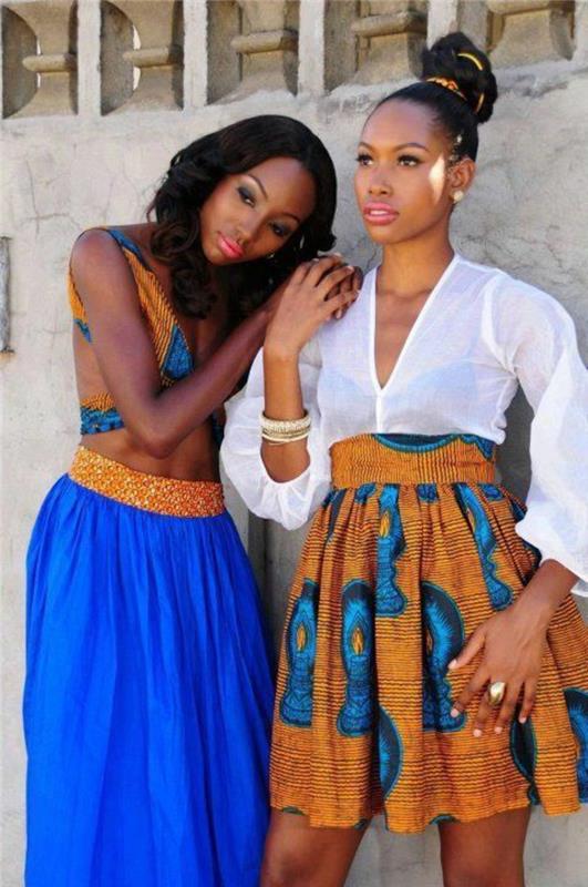 dvi išvaizdos su dviem afrikietiškais sijonais, viena ilga ir viena mini, afrikietiška apranga, aukšti juosmeniai, spalvingų afrikietiškų raštų viršutinė dalis be rankovių ir pusiau permatomi marškiniai ilgomis rankovėmis