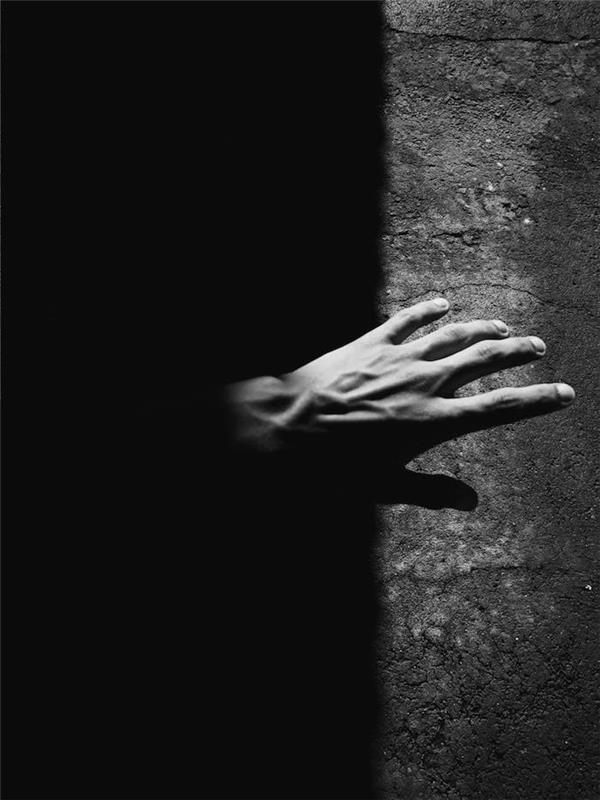 Roka v temno črno -beli foto umetnosti, ideja, ki jo simbolizira belo in črno, umetniška fotografija