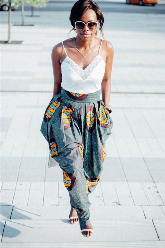 kaip gerai apsirengti vasarą moteris, afrikietės apranga plačiomis kelnėmis su kišenėmis ir baltu viršumi kartu su smėlio spalvos basutėmis