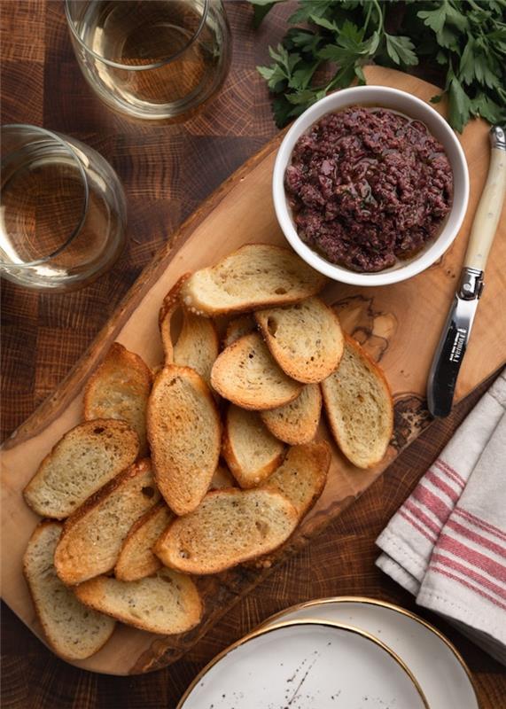 crostini ve iki beyaz şarap kadehi ile bir sos teknesinde yayılmış ev yapımı tepanade