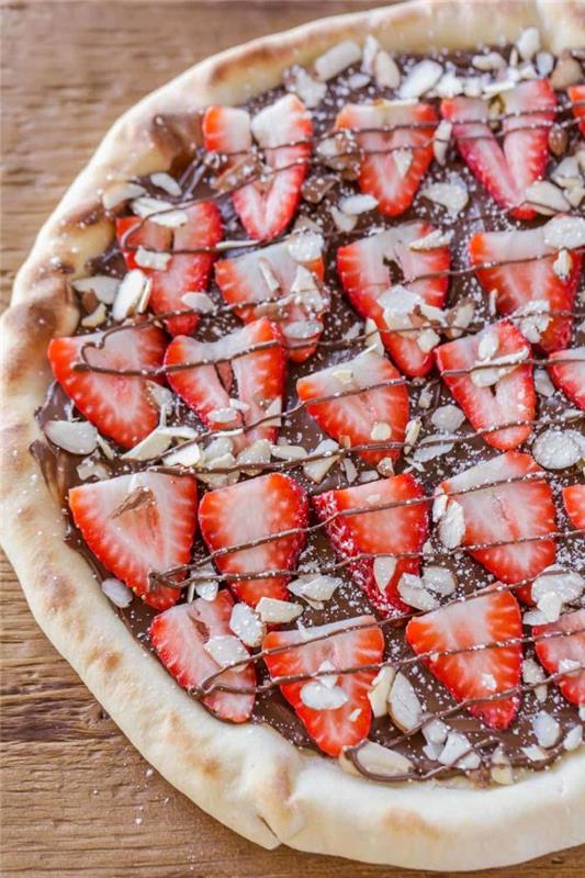 Nutella ve kıyılmış bademli çilek ile yapılan tatlı ev yapımı pizza, orijinal bir çikolatalı tatlı yapar.