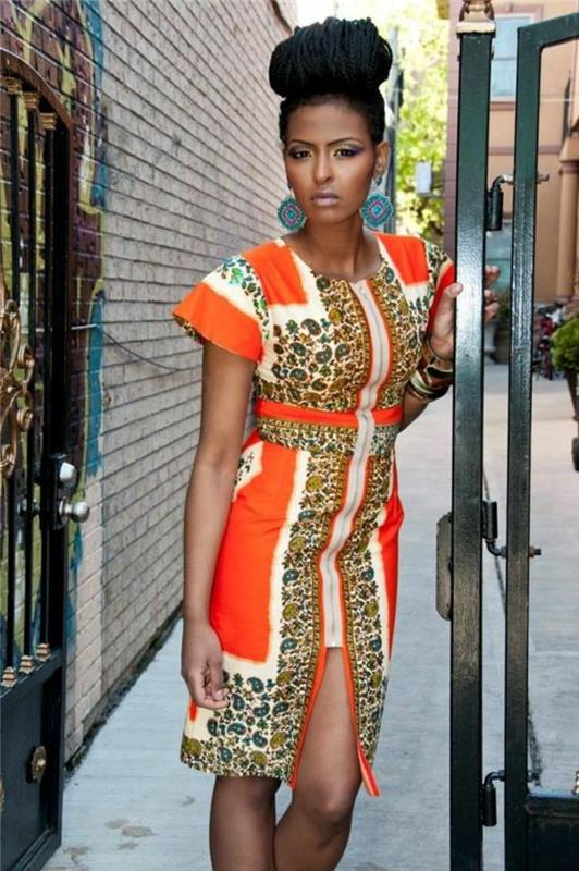 seksuali moters išvaizda, afrikietės apranga, afrikietiška suknelė, afrikietiškas raštas baltos oranžinės spalvos ir tigro atspaudais, griežtas modelis, išryškinantis gana moteriškas kreives
